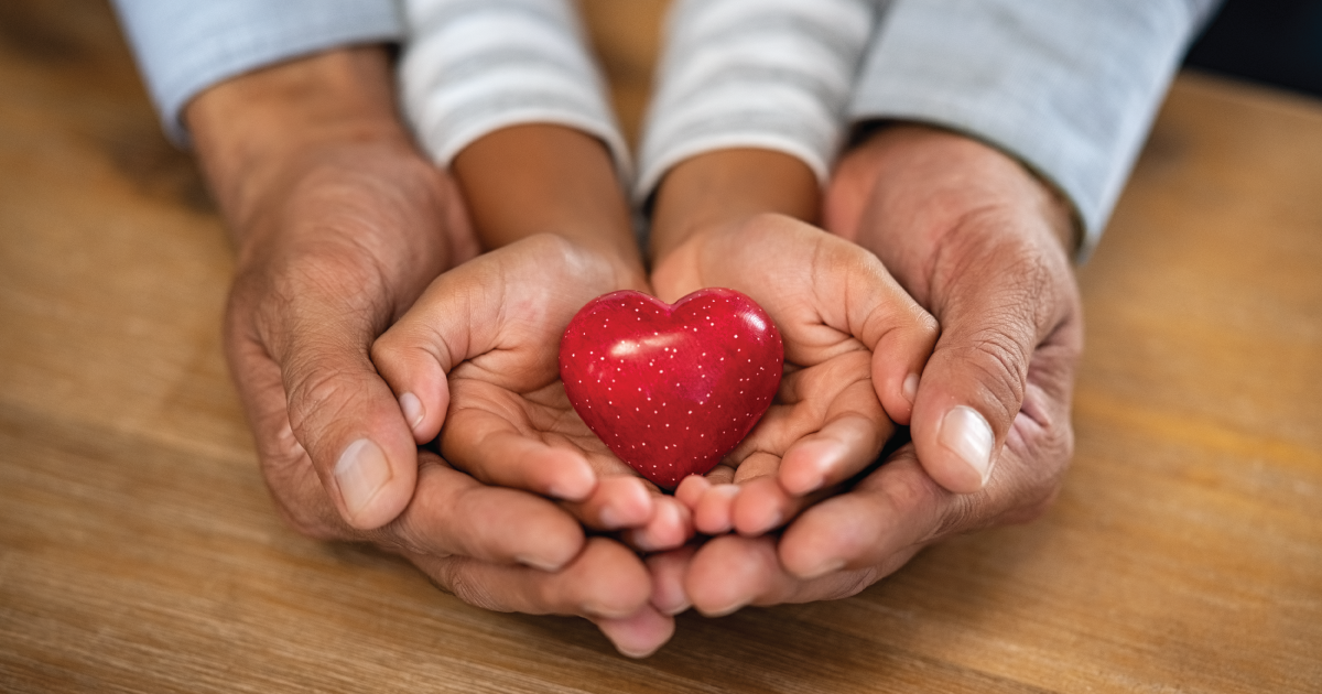 Two people holding a heart in their hands